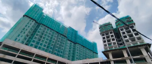 The two 18-storey towers of IX SURIA Residences rising under construction, May 2026.